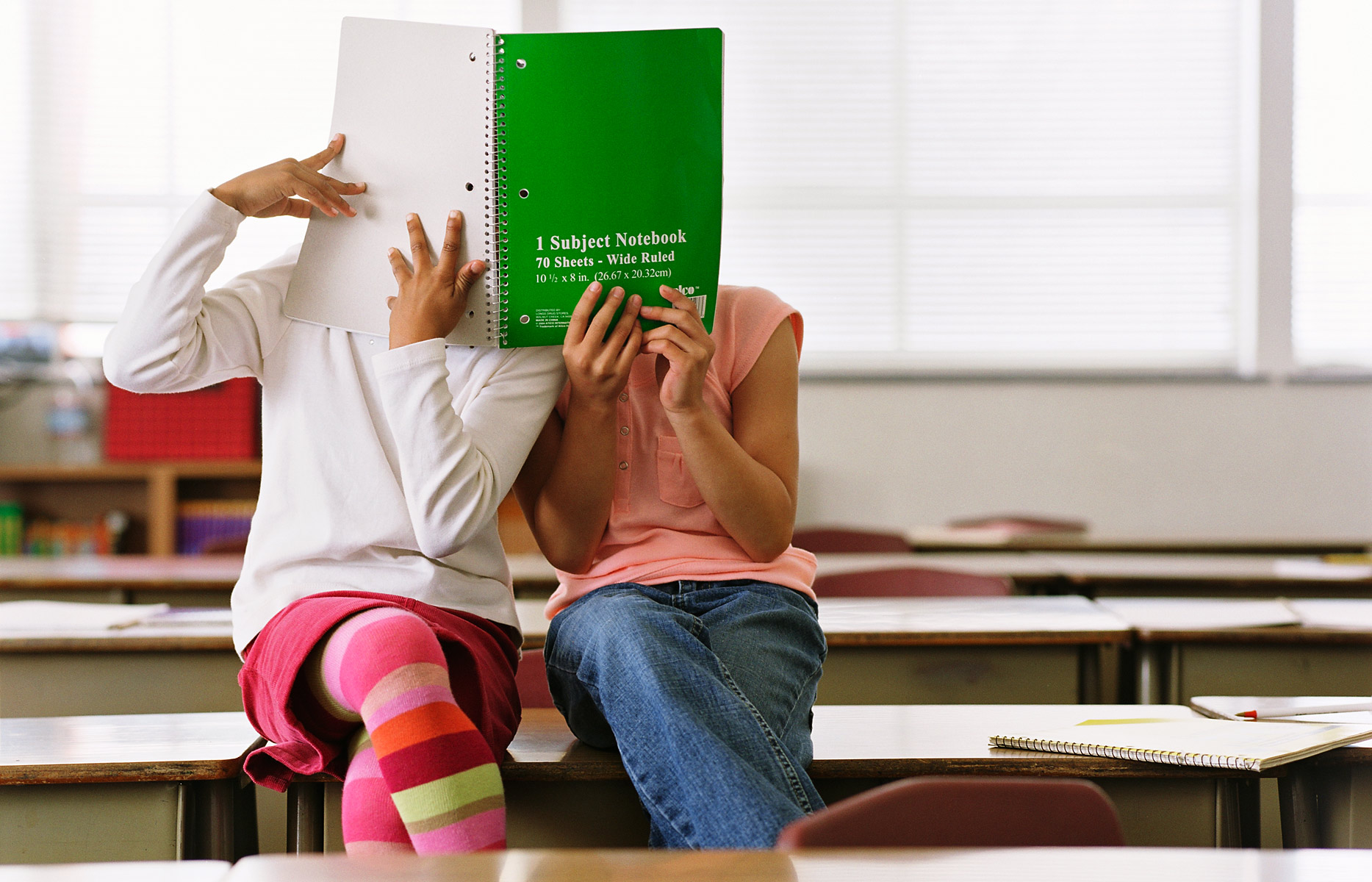 girls_in_classroom_with_green_notebook_over_their_faces-book_end_girls-spread